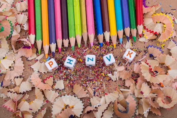 Color Pencils and letter cubes on the pencil shavings