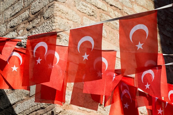 Turkish national flag hang on a pole on a rope in the street in open air