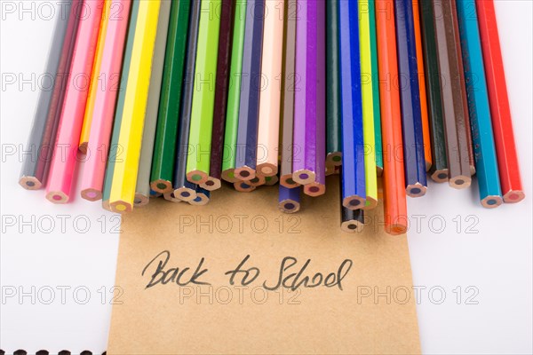 Color pencils and back to school title on a notebook