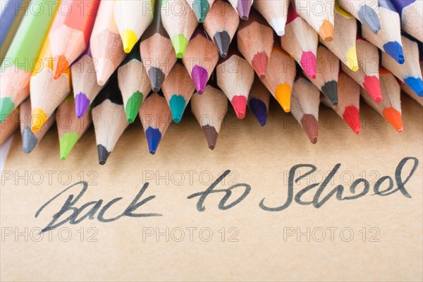 Color pencils and back to school title on a notebook