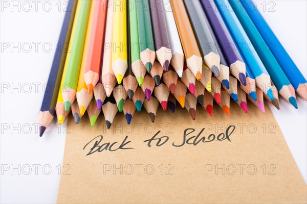 Color pencils and back to school title on a notebook