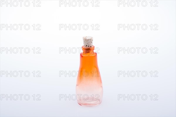 Child holding a little colorful empty glass bottle on a white background