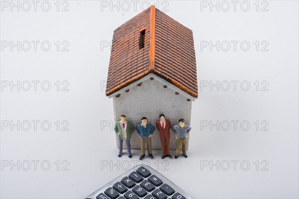 Tiny Fiigurine of man and calculator ibeside a house