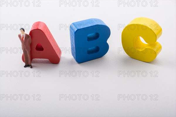 Man figurine and Letters of abc of alphabet on white