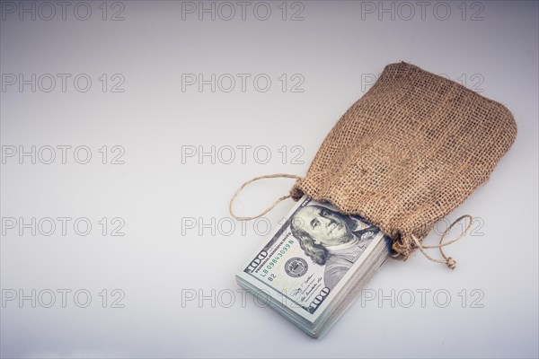 Banknote bundle of US dollarin a sack on a white background