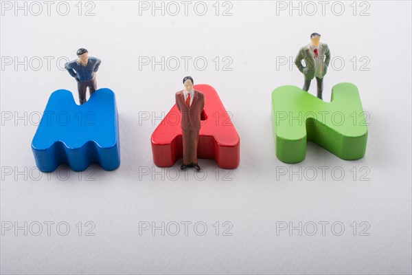 Tiny figurine of men beside colorful wooden letters say MAN