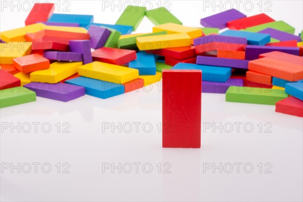 Hand playing with colored domino on white background