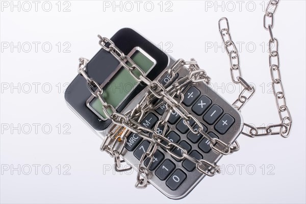 Calculator wrapped in chains on a white background