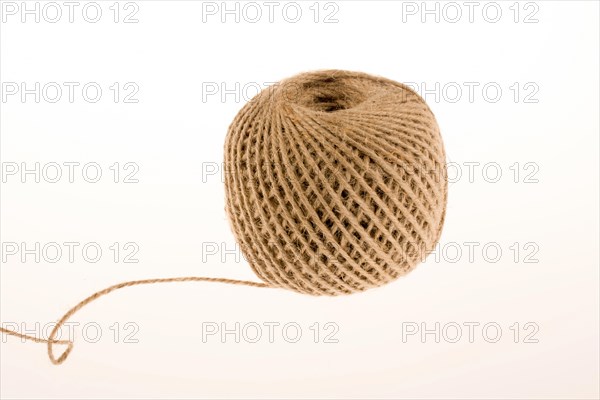 Roll of brown color linen string on a white background