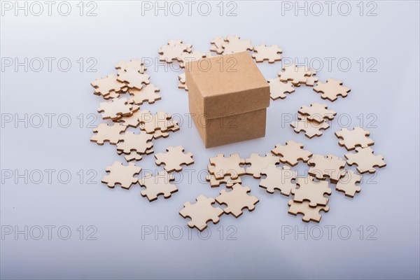 Pieces of jigsaw puzzle around box as problem solution business concept