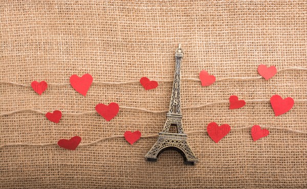 Love concept with Eiffel tower and paper heart on threads