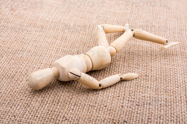 Wooden dolls of a man posing on canvas