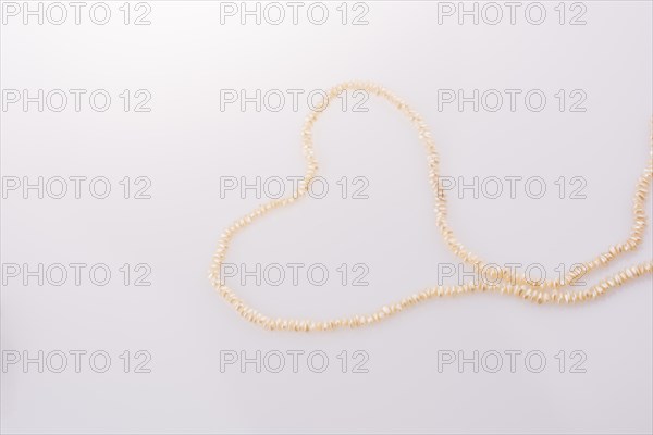 Pearl necklace is placed on white background