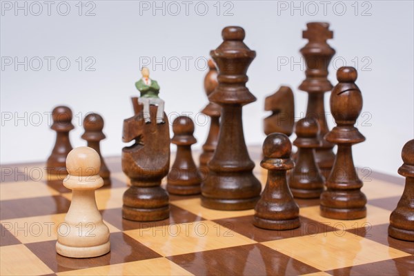 Man figurine thinking on chessboard as strategy and leadership concept