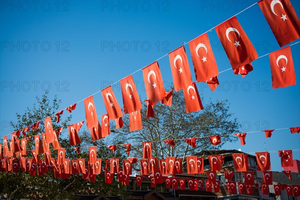 Turkish national flag hang on a pole on a rope in the street in open air