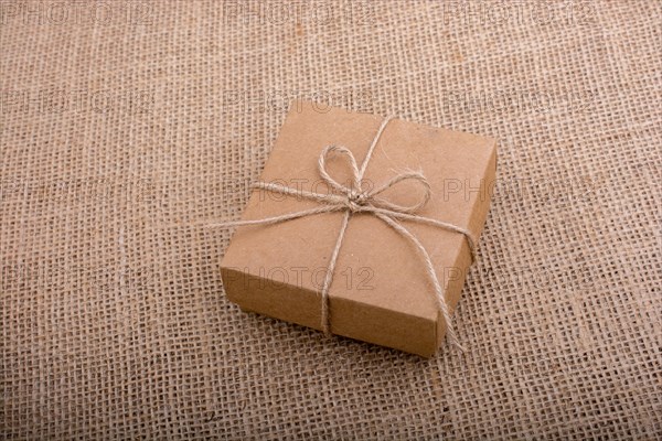 Gift box of brown color on linen canvas