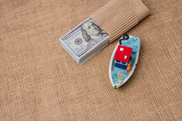 Model boat and banknote bundle of US dollar on canvas