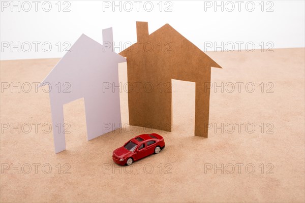 Paper house and a model car on a canvas background