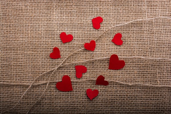 Love concept with heart shaped papers on linen threads