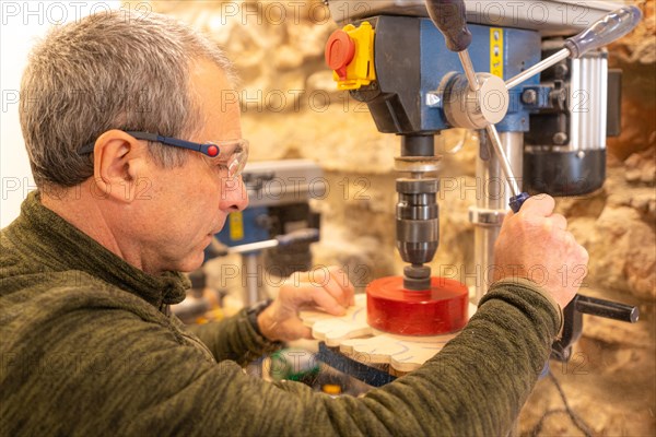 Close-up of a carpenter polishing a piece of wood in studio workshop