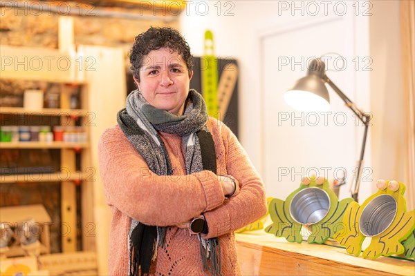 Portrait of a mature female artisan in a workshop standing and smiling in a workshop