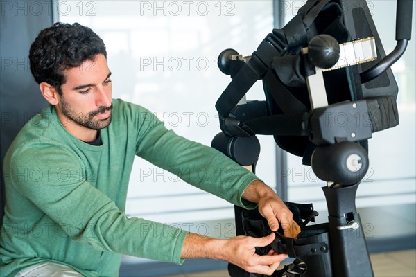 Mechanical exoskeleton engineer checking the mechanisms before the arrival of patients. Physiotherapy in a modern hospital: Robotic skeleton. Physiotherapy Rehabilitation Scientists