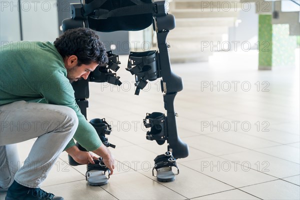 Mechanical exoskeleton engineer checking robot before delivery to customer. Physiotherapy in a modern hospital: Robotic skeleton. Physiotherapy Rehabilitation Scientists