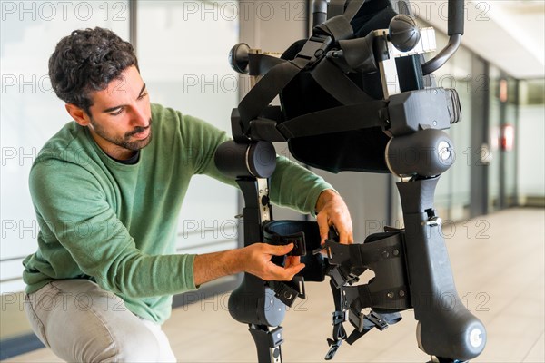 Mechanical exoskeleton engineer checking robot before delivery to customer. Physiotherapy in a modern hospital: Robotic skeleton. Physiotherapy Rehabilitation Scientists