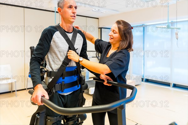 Mechanical exoskeleton. Female physiotherapy medical assistant with disabled person lifted with robotic skeleton. Futuristic rehabilitation