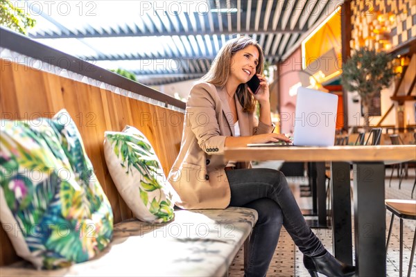 Distracted woman taking a break to remote work using laptop in a cafeteria in a department store