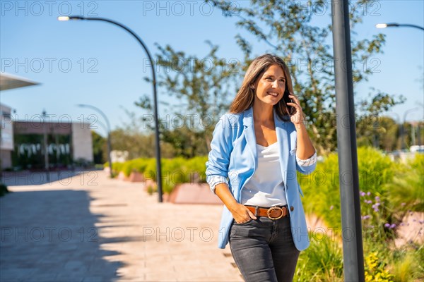 Business woman talking to the phone while move along a residential area. Concept of business on the move