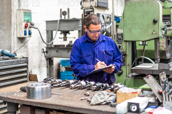 Factory worker operator in the numerical control sector making a report