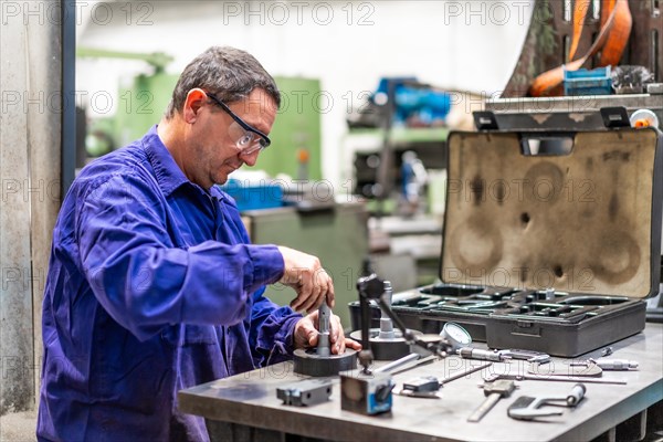 Factory worker operator in the numerical control sector checking the equipment