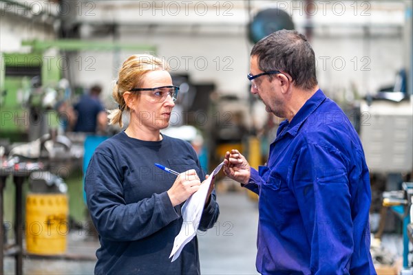 Metal industrial factory workers from the numerical control sector working on a machine