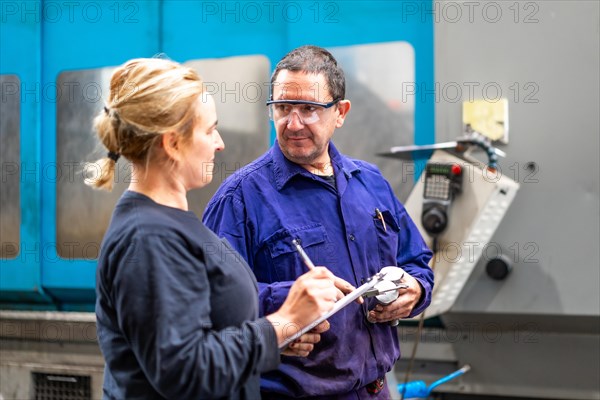 Metal industrial factory workers from the numerical control sector talking making a report