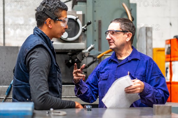 Metal industrial factory workers from the numerical control sector talking