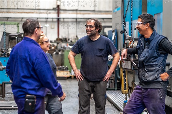 Team of workers from the metal industrial factory trade in the numerical control sector talking