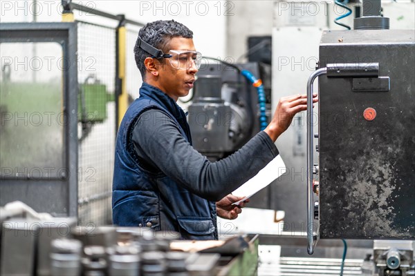 Latino worker operator in the metal industrial factory trade in the numerical control sector