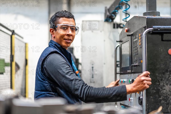 Portrait of Latin industrial worker in the metal industrial factory trade in the numerical control sector