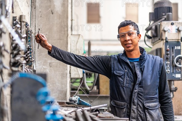 Latino worker in the metal industrial factory trade in the numerical control sector
