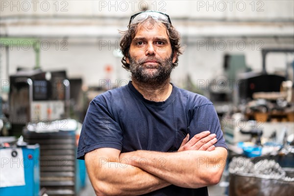 Portrait of a metal industrial factory worker in the numerical control sector with his arms crossed