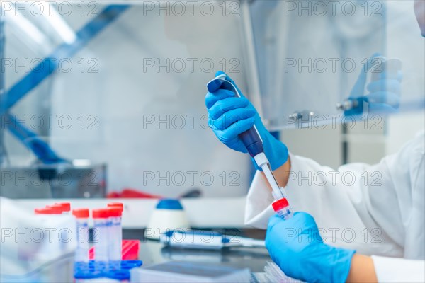 Side view close-up of an unrecognizable scientist making a test tube in a laboratory using pipette