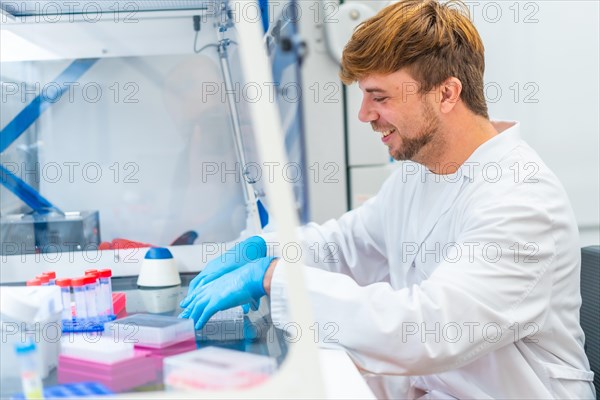 Young scientist working on cells in a cancer research and infectious diseases laboratory