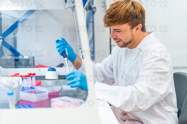 Side view of a young biologist using pipette in a innovative laboratory