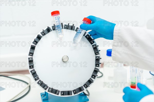 Top view of a scientist placing samples in centrifuge machine