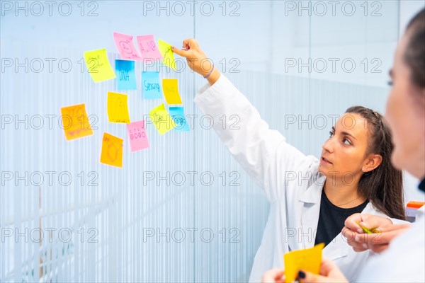 Biologist pointing a note during a creative research process in a laboratory