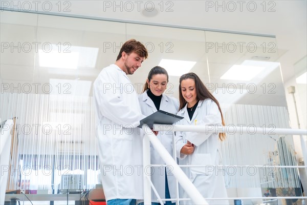 Young doctors working in a cancer research laboratory standing talking and analyzing data