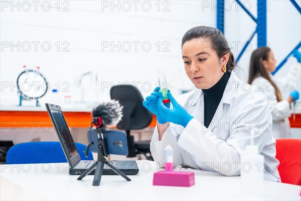 Scientist recording a video tutorial using phone sitting in a research laboratory