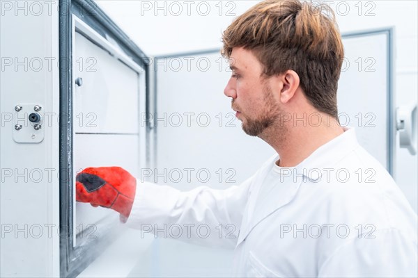 Side close-up view of scientist freezing samples in a cancer cell research laboratory