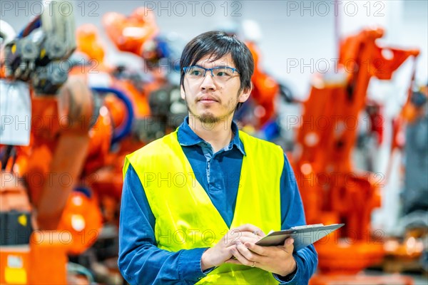 Engineer controlling the line of production of a robotic arms